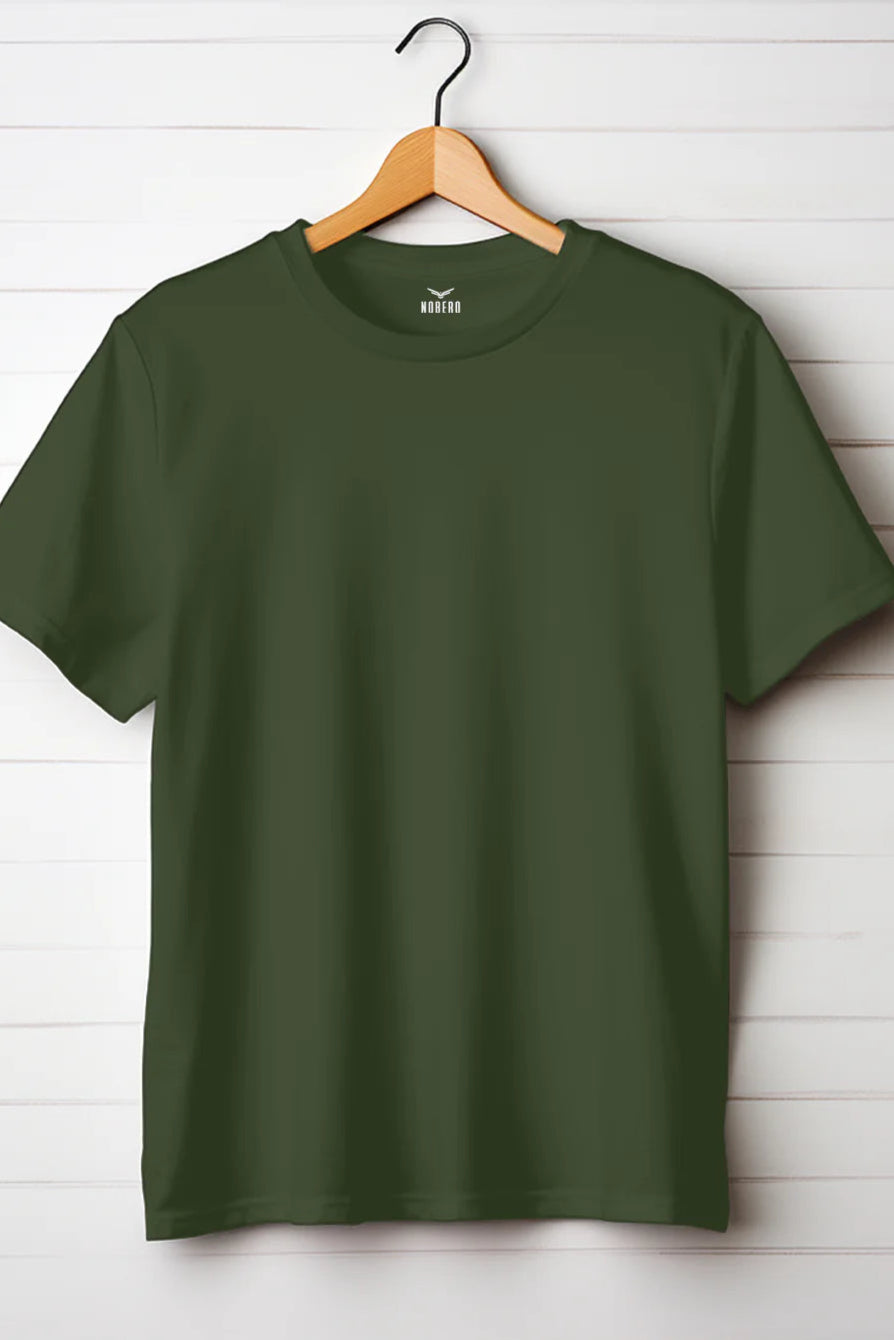 Plain olive green men's t-shirt hanging on wooden hanger against white wooden wall – classic casual wear by Xstort